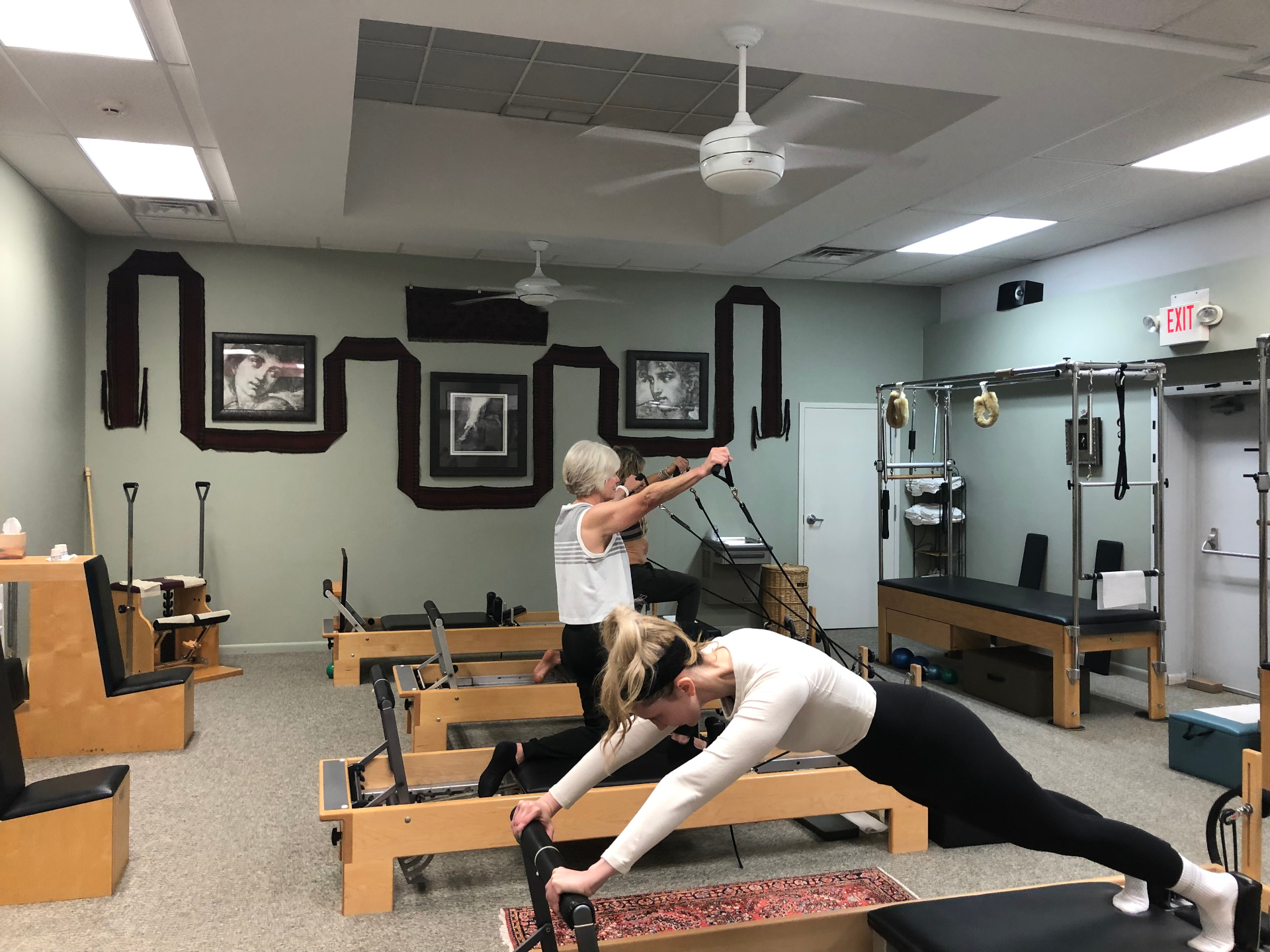 Clients practicing Pilates on reformers at Studio Pilates